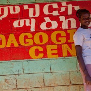 An Ethiopian girl who is part of the PROSPER program waits outside of her classroom (for Mercy Corps International)