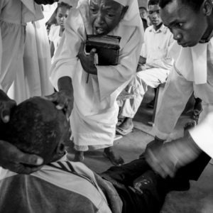 Shepherds get closer to the demons in a man during a demon driving ceremony in Madagascar